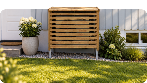 Varmepumpehus i tre på plenen inntil en husvegg