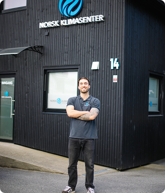 Montør kontrollerer en varmepumpe utendørs